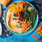 Harvest bowl displaying Hummus, carrots, sliced beetroot, Asparagus, cauliflower